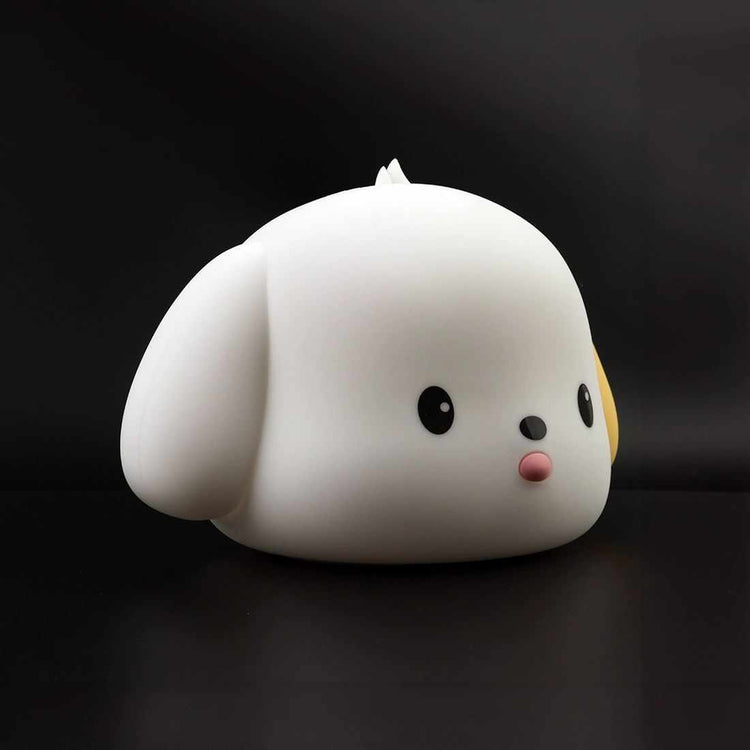 spotted puppy night light made of soft silicone, shaped like a cute squishy puppy with black eyes and a pink nose on black background