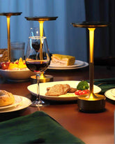 LumiHikari Base Lamp providing warm ambient light on a dining table with food and wine glass